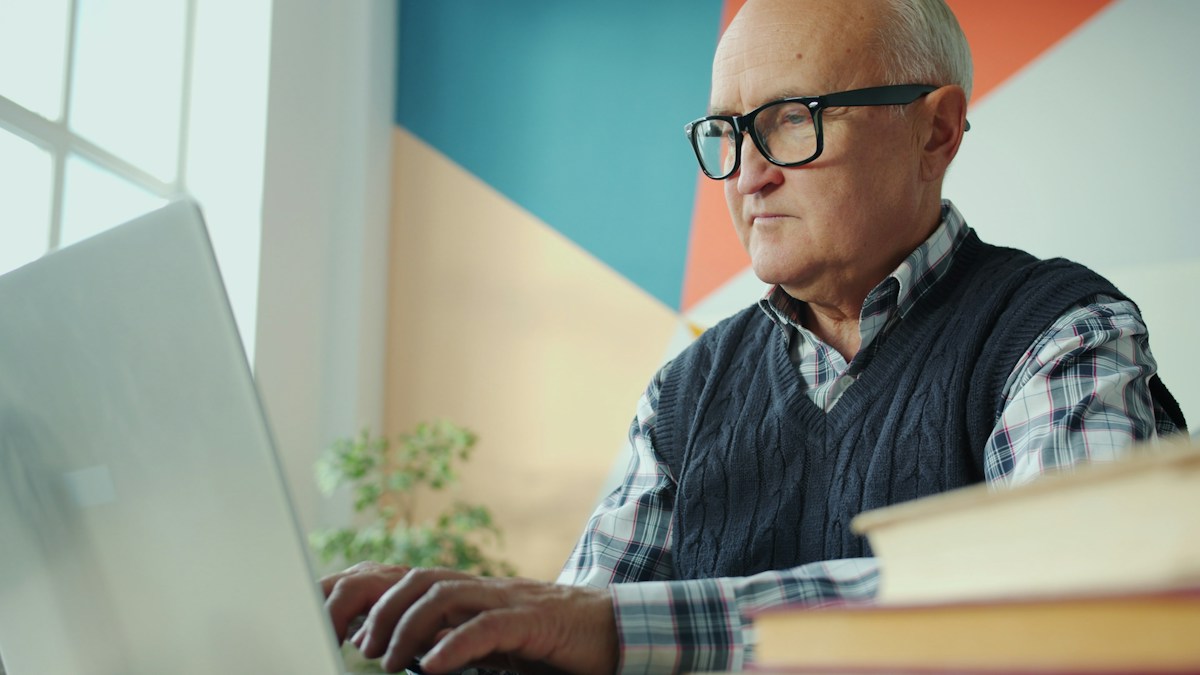 Homme senior travaillant sur un ordinateur portable à son bureau